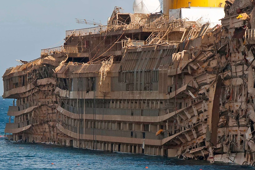 Exterior of one side of the ship, barely recognisable with crushed cabins and balconies.