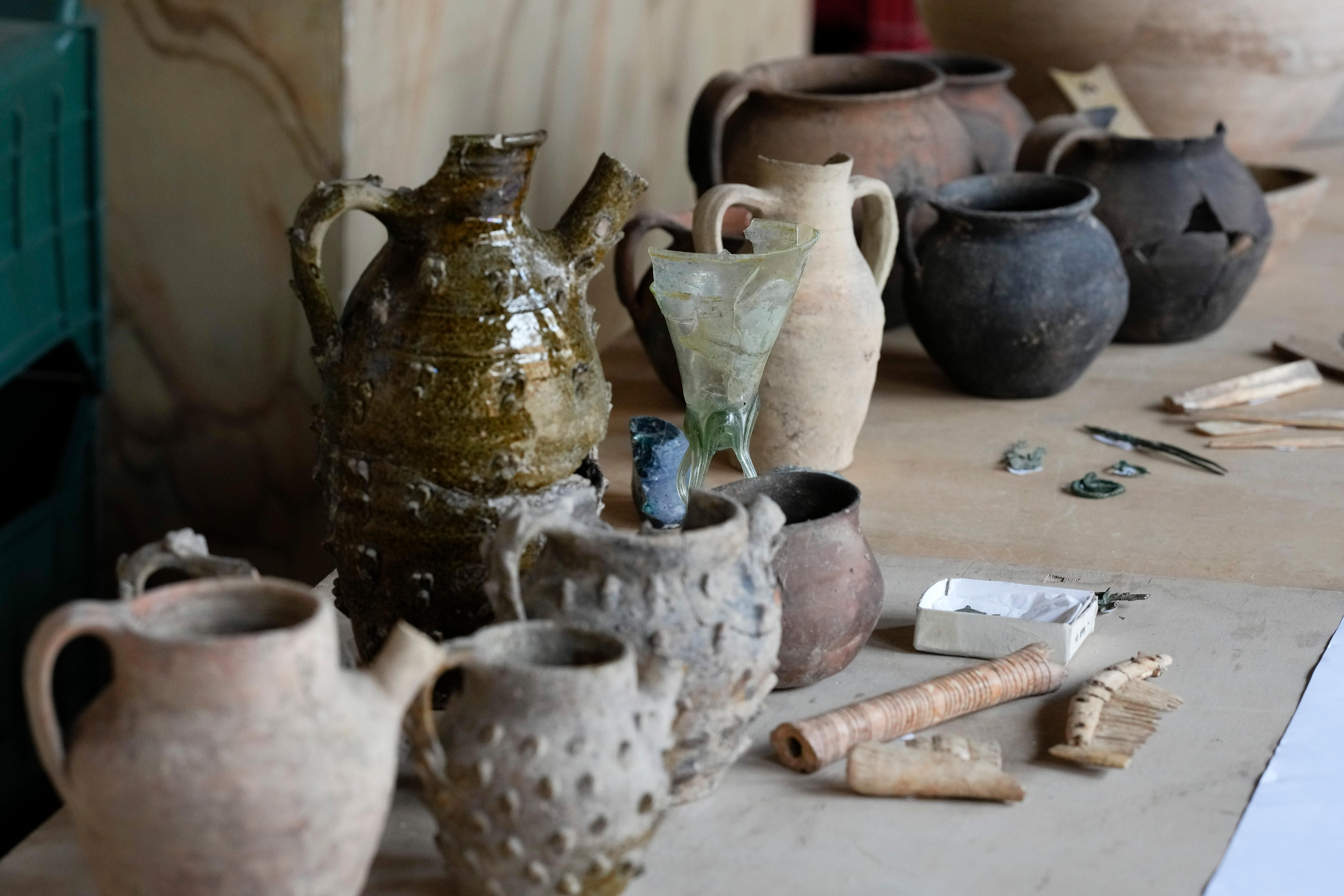 a collection of ancient medieval artefacts including ceramic jugs displayed on a table