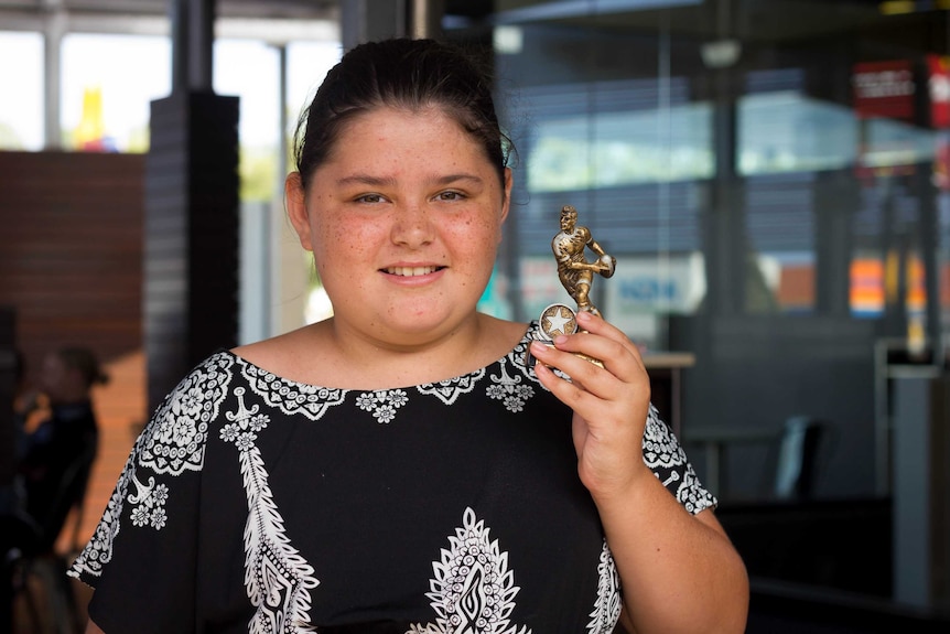 Tyrone Unsworth's cousin Rosie holds a rugby league trophy, 2017