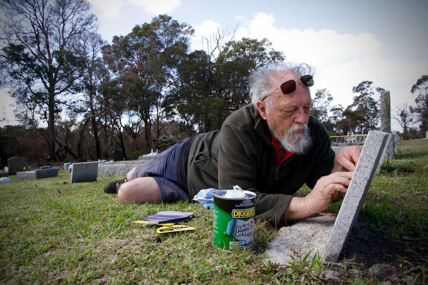 Tombstone Fairy Ross McGuinness paints a headstone at Denmark cemetery