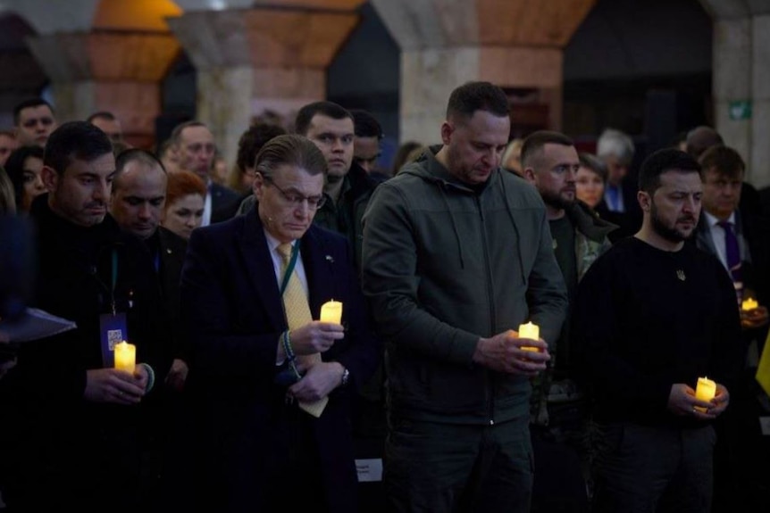 WA Ombudsman Chris Field stands in a candle-lit vigil with Ukrainian president Volodymyr Zelenskyy.