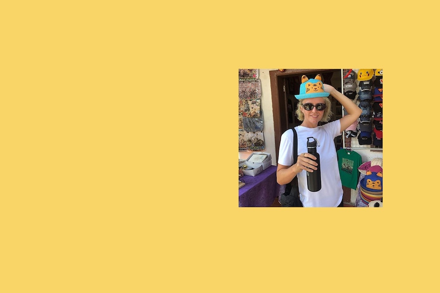 A young woman wearing a kitty hat in a market.