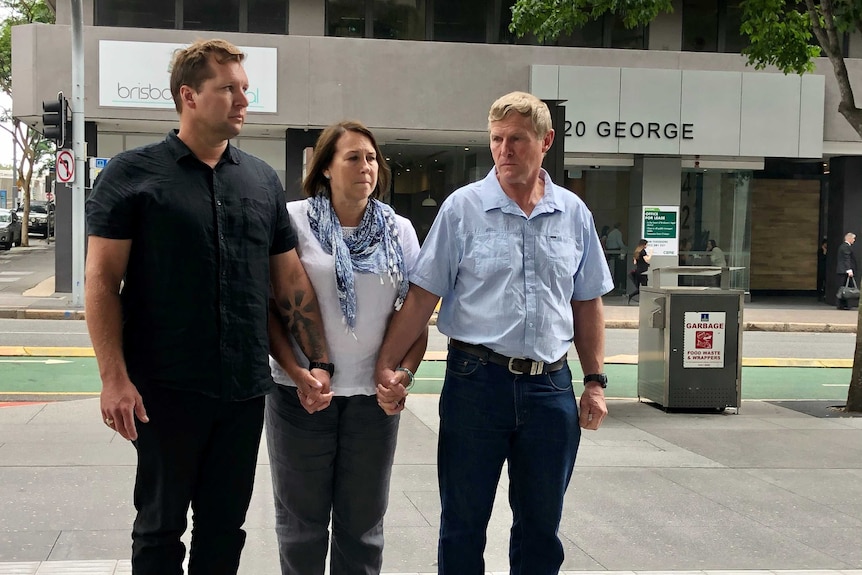 Tom Davy's brother, mother and father holding hands.