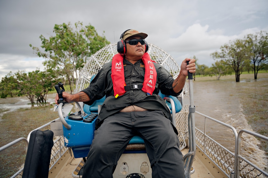 A man driving a waterboat through a tropical marsh