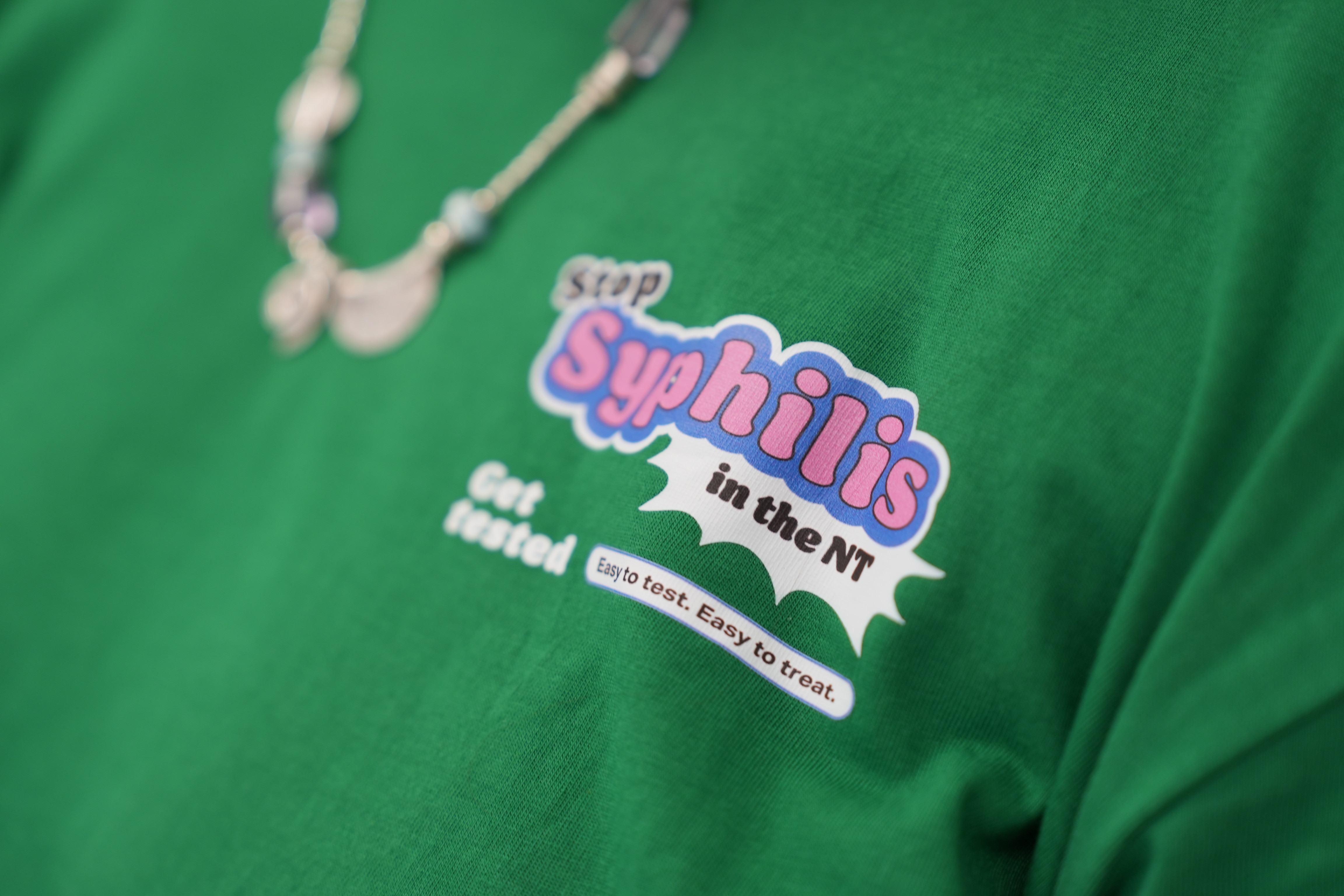 A green shirt reads: Stop syphilis in the NT, get tested