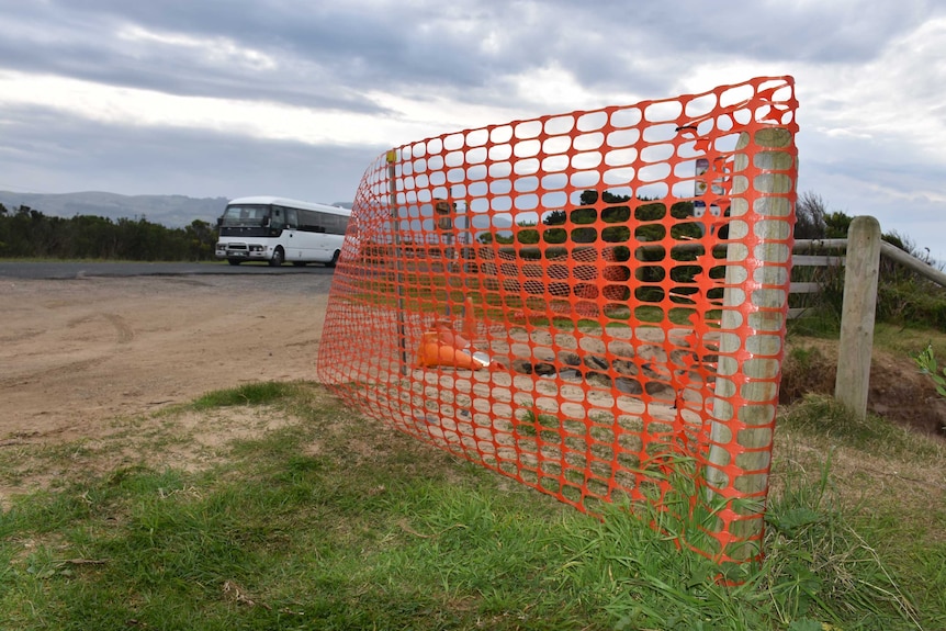 A bus drives past a sectioned-off area of erosion on the Great Ocean Road at Marego, near Apollo Bay.