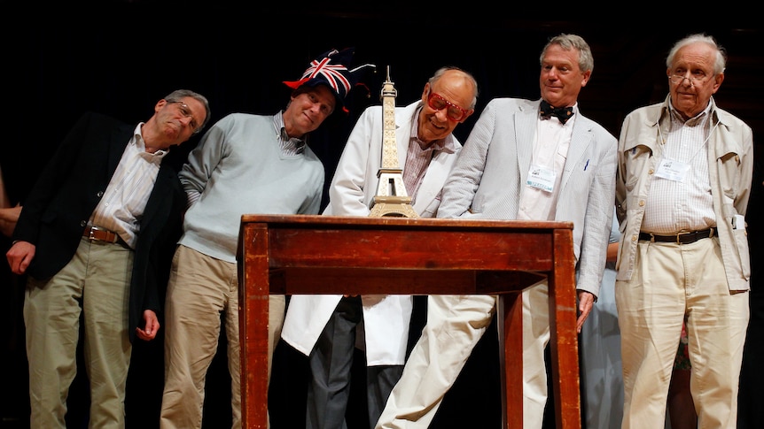 Nobel laureates lean as they look at Eiffel tower