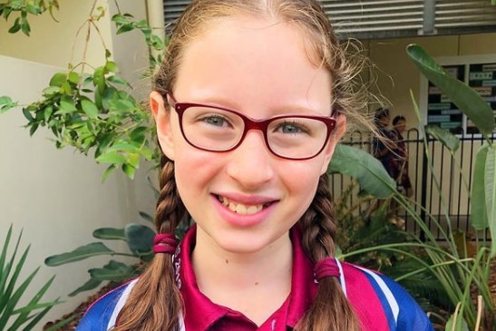 A smiling Sophie with glasses and plaits.