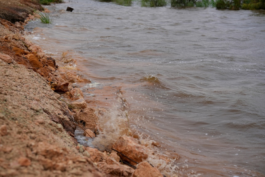 Waves of water splashing onto a levee 