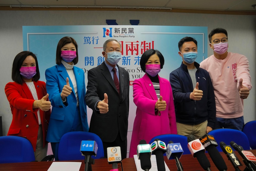 A group of election candidates hold their thumbs up for a photo