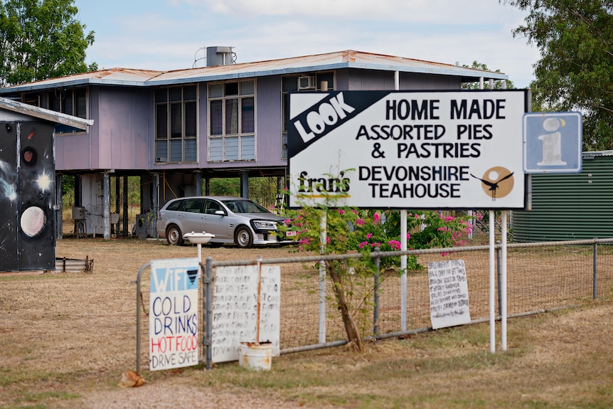 A sign reading 'home made assorted pies' and 'devonshire teahouse' out the front of a house.