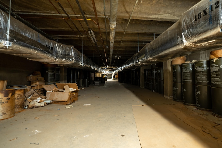 A photo of a long, dusty underground tunnel filled with boxes