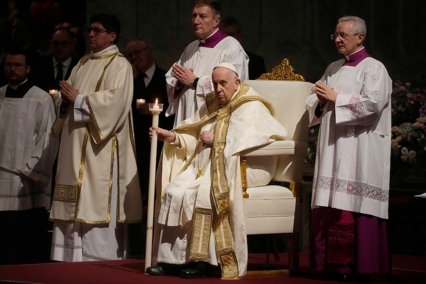 Pope Francis holds a Paschal candle as he presides over a Easter vigil ceremony in St. Peter's Basilica at the Vatican.