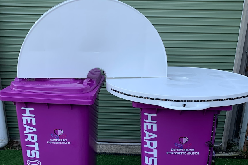 Two purple bins one with table on top and the other with white table folded flat