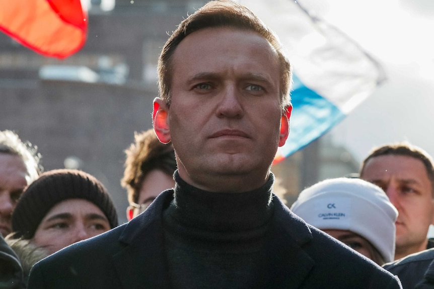 A man in a dark jacket stands in the street.