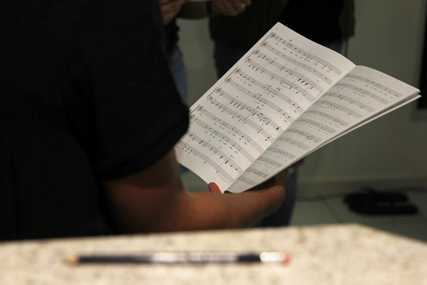 A choir singer reading off sheet music.