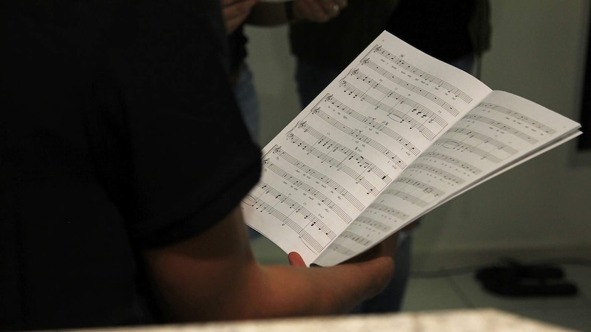 A choir singer reading off sheet music.