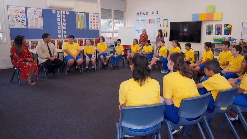 Class room of students in uniform sitting in a semi circle