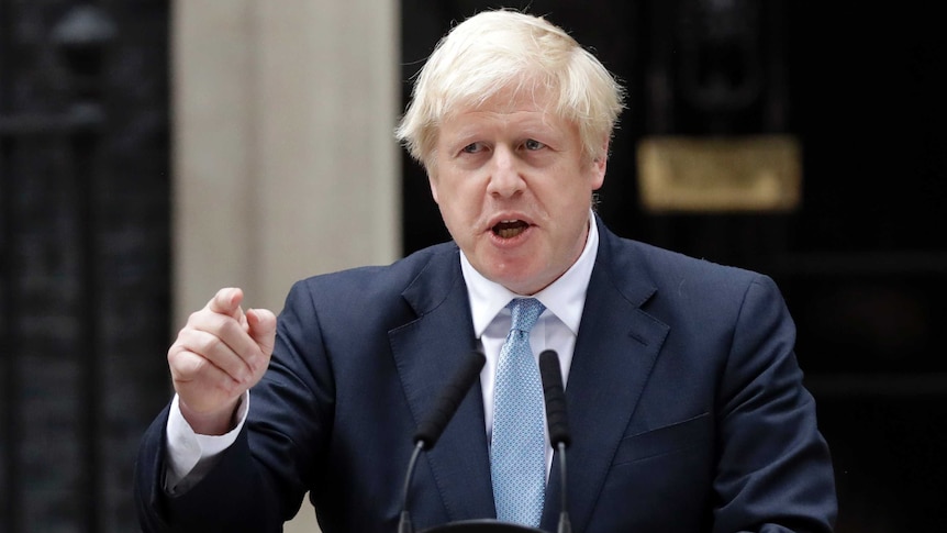 Boris Johnson gestures as he gives a speech in front of 10 Downing Street.