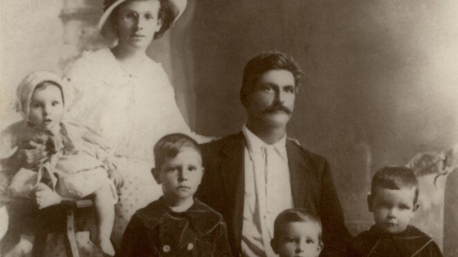 A family of six poses for a black and white photo