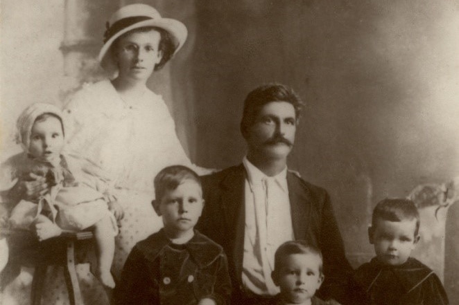 A family of six poses for a black and white photo