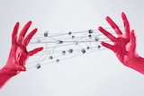 Red hands hold a complicated cats cradle with boxes suspended throughout.