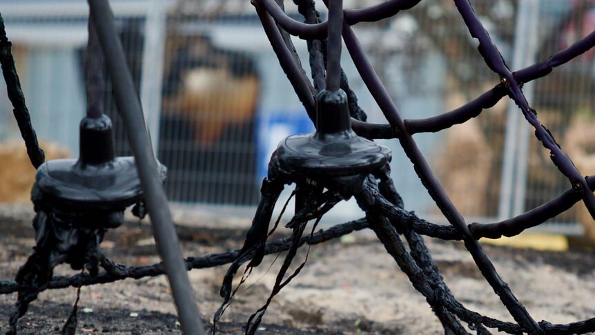 A climbing frame on a children's playground is black and the plastic melted.