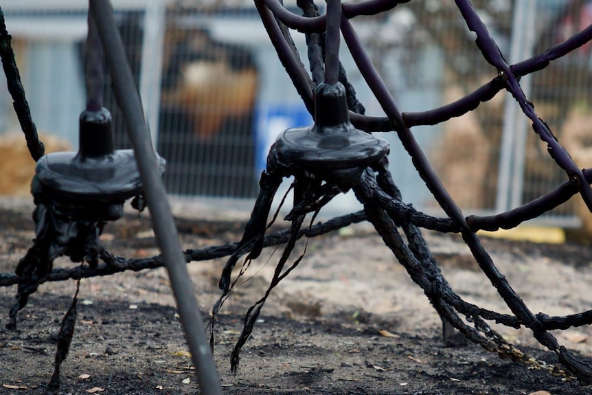 A climbing frame on a children's playground is black and the plastic melted.