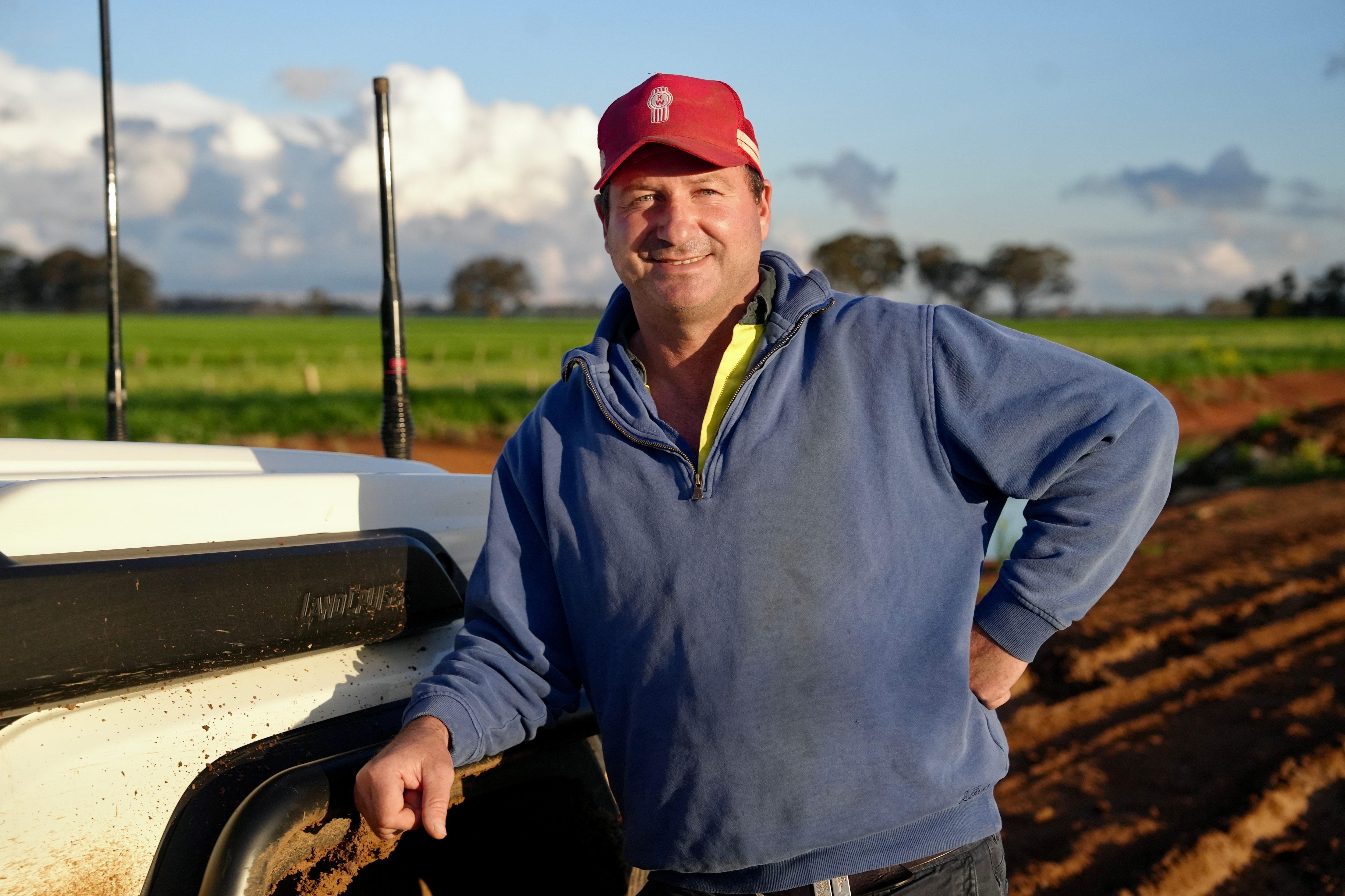 A man stands in a rural paddock looking at the camera