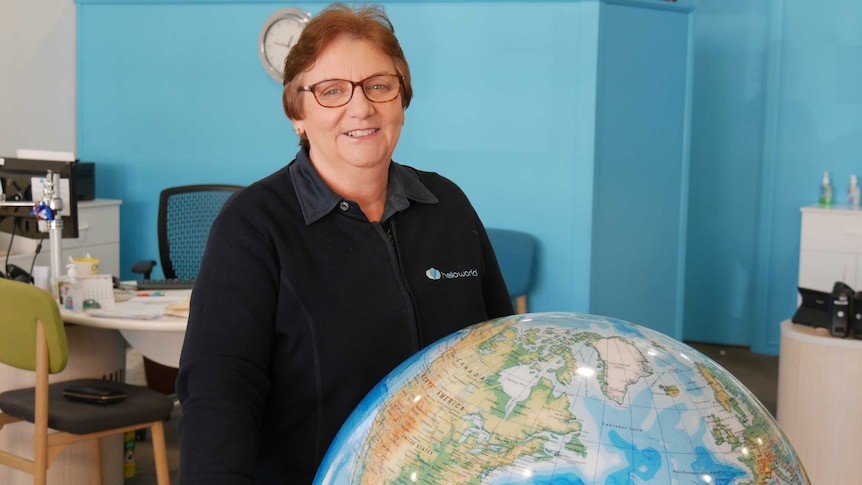 Travel agent stands behind world globe