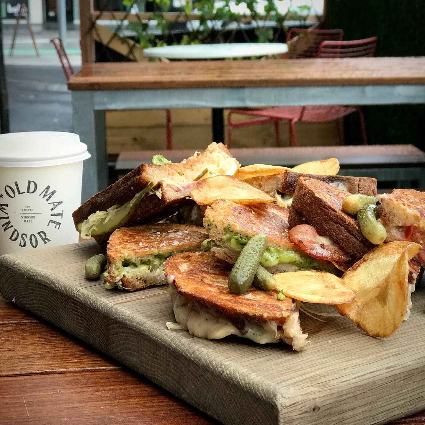 A coffee cup and toasties served on the table. 