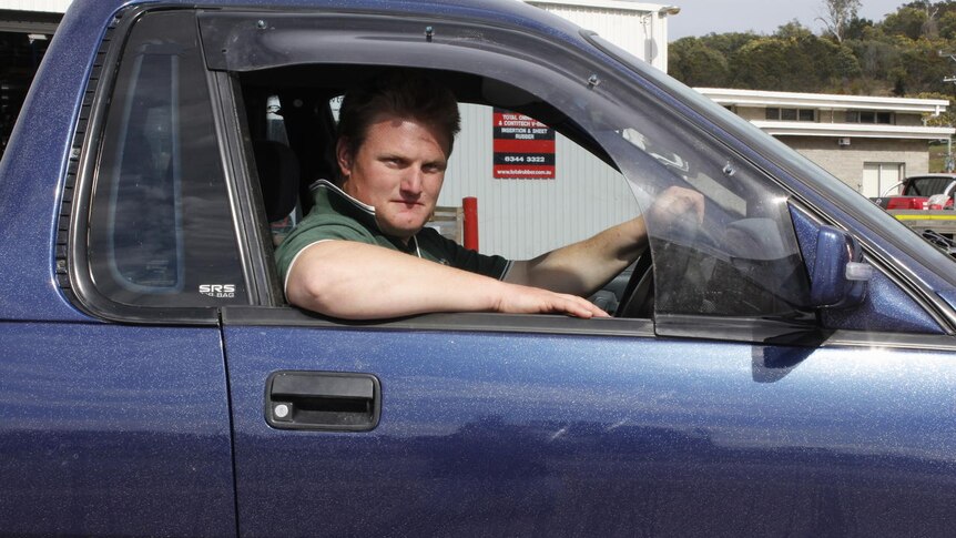 A man in a purple ute