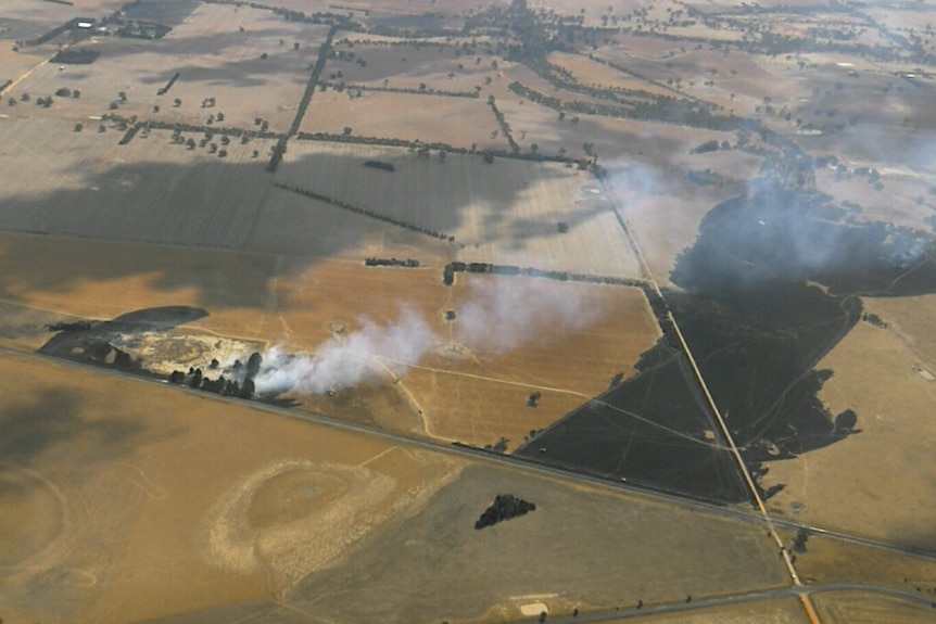 a shot from a plane of smoke coming out of dry paddocks.