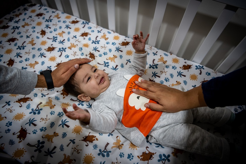 A baby in a cot.