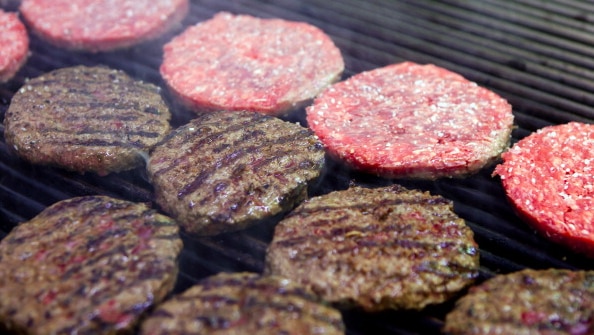 Hamburgers cook on a grill in the kitchen of an h3 Hamburger Co. restaurant in Lisbon, Portugal, on Saturday, March 3, 2012