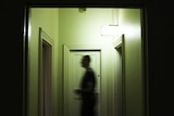 Man passing through a dark corridor at a hotel