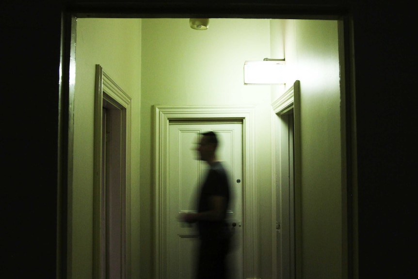 Man passing through a dark corridor at a hotel