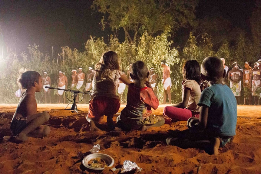 Indigenous children watch traditional dancing at a Kimberley cultural festival.