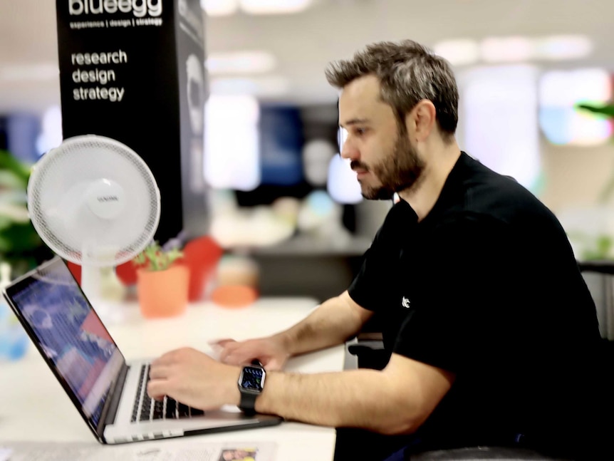 Stockspot founder Chris Brycki types on a laptop in the company's office in Sydney's CBD.