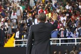 Barack Obama waves to the crowd at an indoor stadium in Nairobi