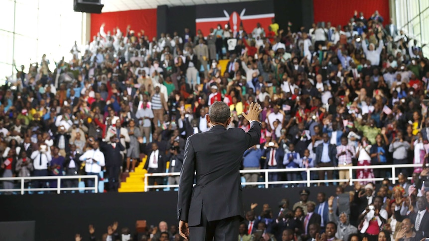 Barack Obama waves to the crowd at an indoor stadium in Nairobi