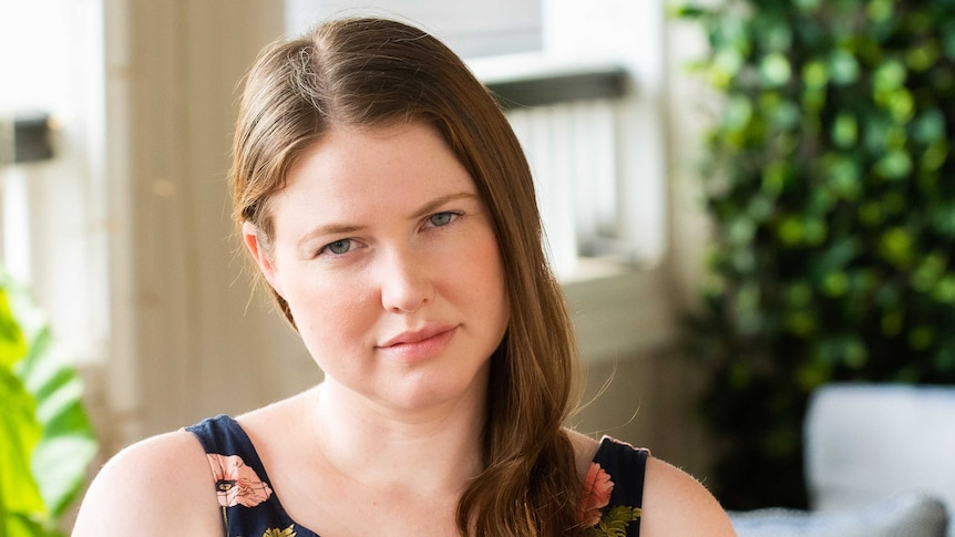 Woman with brown hair looks at camera