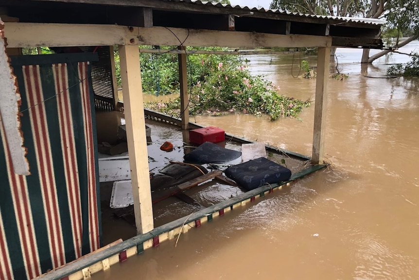 Floodwaters reaching the balcony of a house.