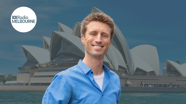 a man in blue shirt against the background of Sydney opera house