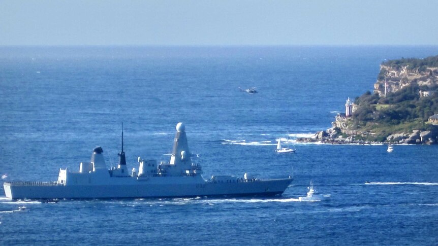 A warship makes its way through Sydney Heads at the start of the International Fleet Review.