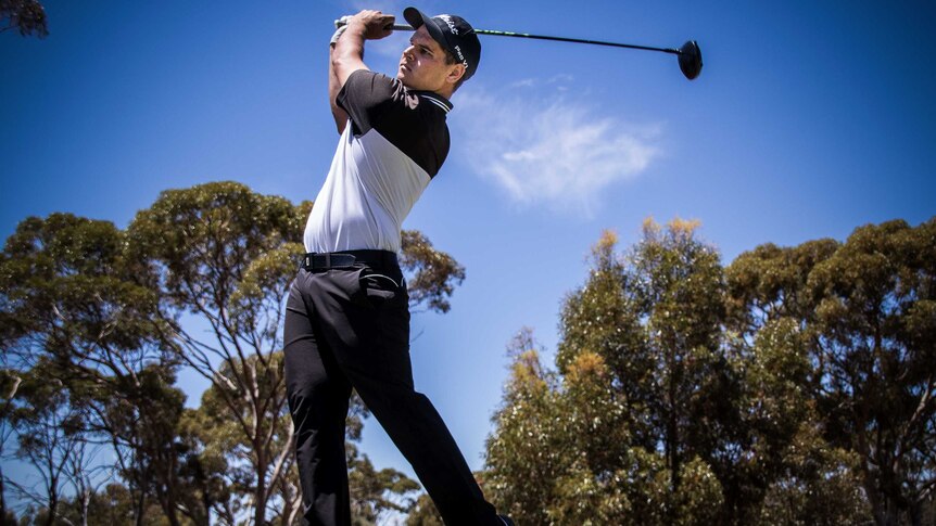 Young golfer plays tee shot.