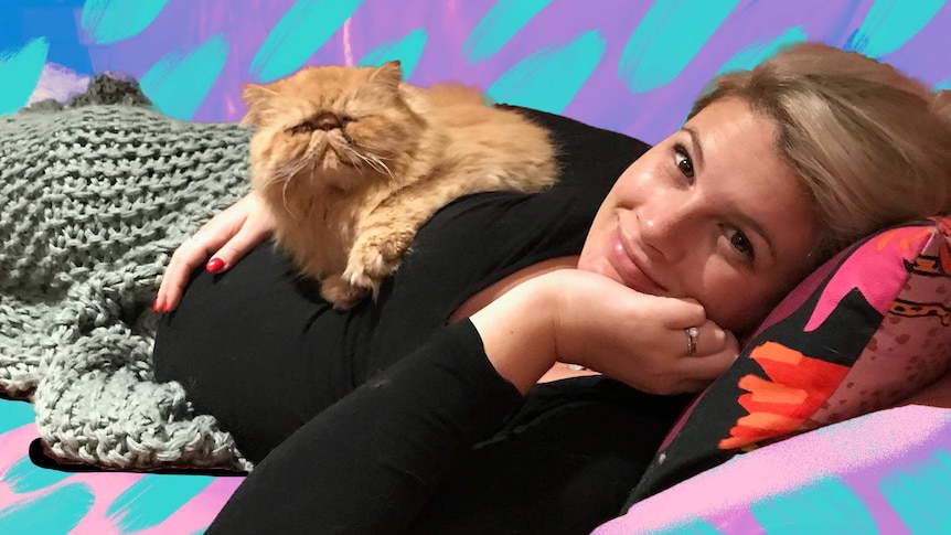 Grace Jennings-Edquist with her angry cat Keith sitting on pregnancy bump