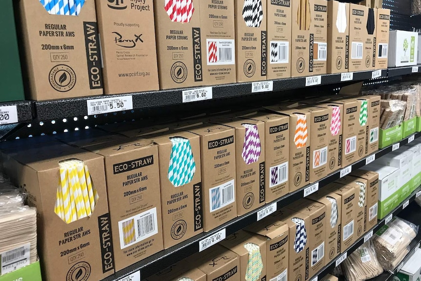 Eco straws stacked in boxes on shelves.
