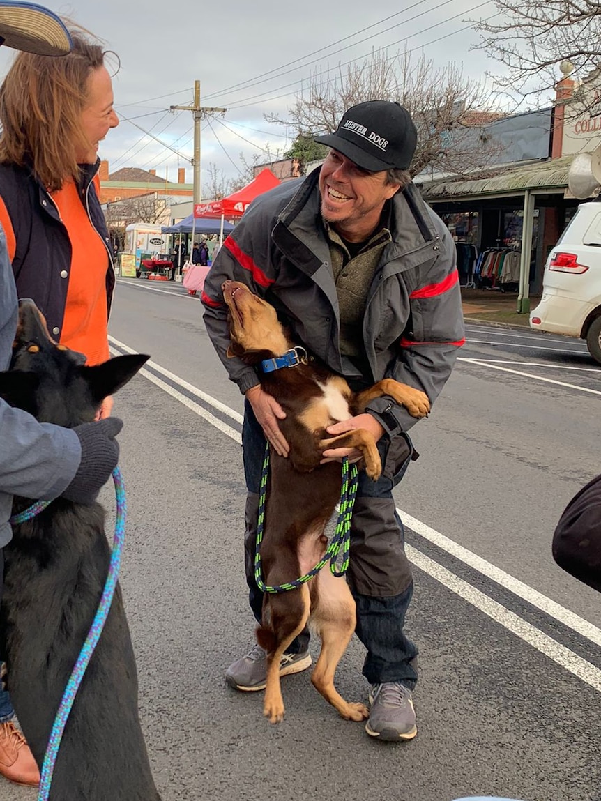 Rob Tuncks laughs and pats kelpie Lucifer