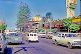 Cars driving down a shop-lined Surfers Paradise street in 1969.